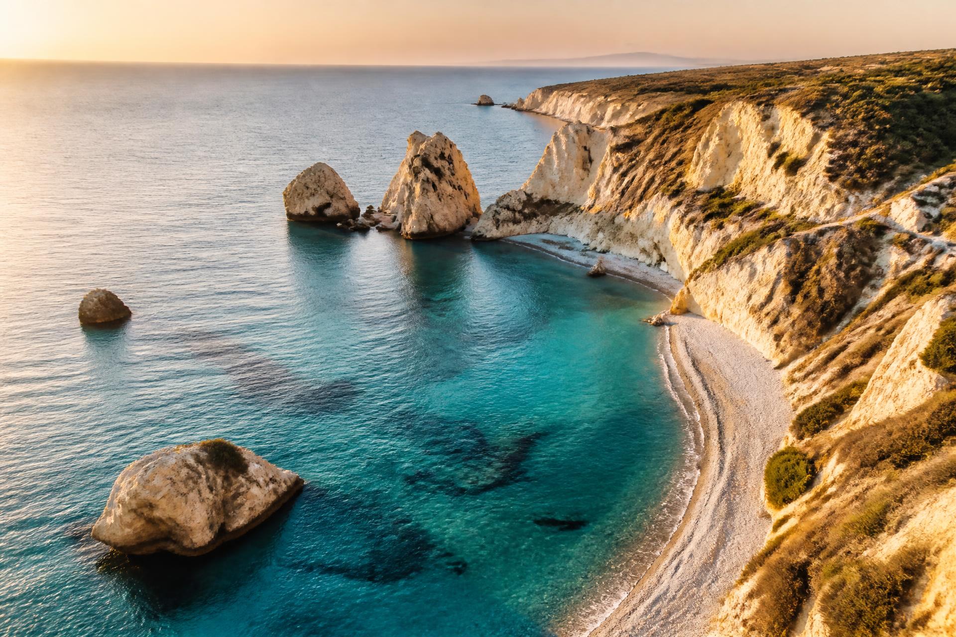 Turquoise Mediterranean bay with pale cliffs and a quiet beach on the Cyprus coast at golden hour